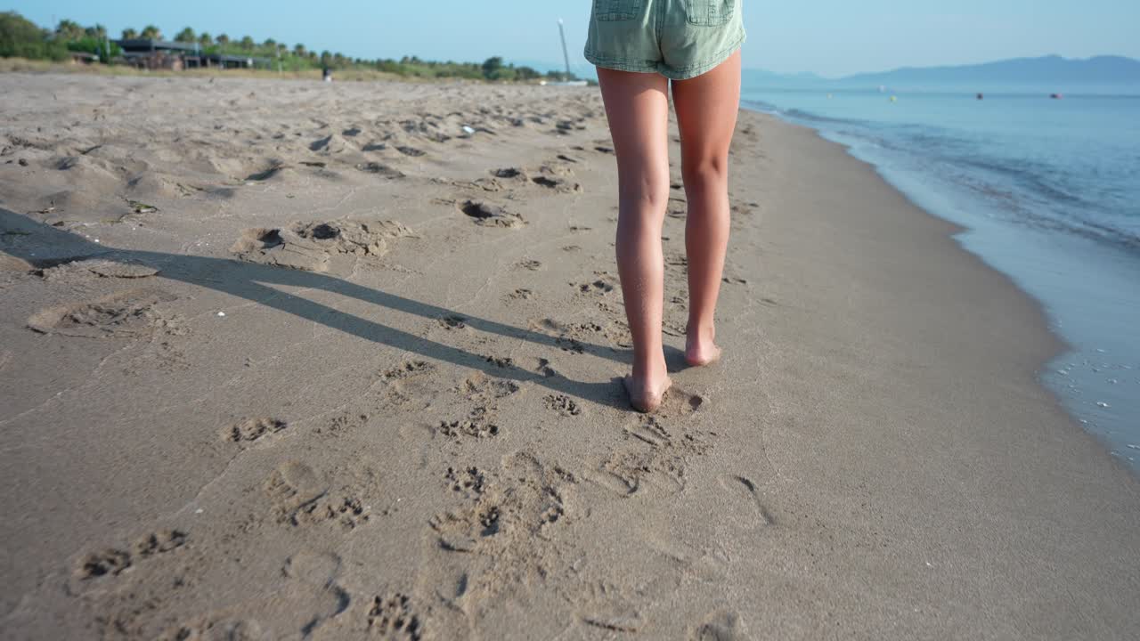 Donna che cammina sulla spiaggia di Sandy