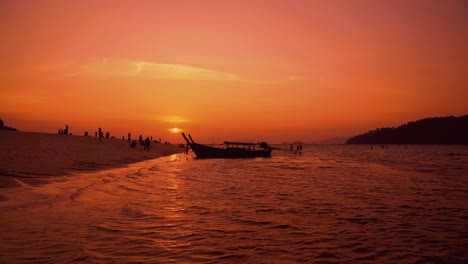 Famous,-traditional-and-iconic-longtail-boat-on-a-sandy-beach-on-the-remote-island-Koh-Lipe-in-Thailand-by-sunset,-close-to-the-Malaysian-border