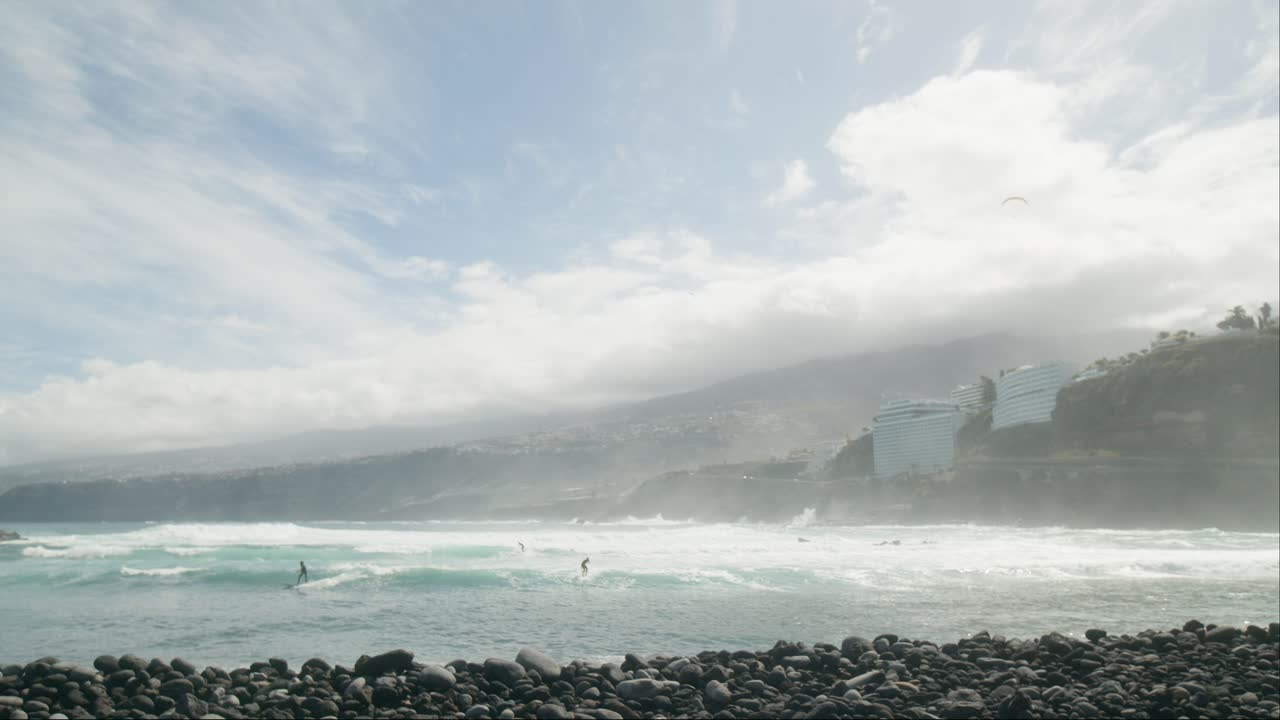 바다의 파도에서 서핑하는 서퍼의 느린 모션 그룹, 바위 해변에서 빨간 발, playa martianez, 푸에르토 데 라 크루즈, 테네리프, 봄에 카나리아 섬