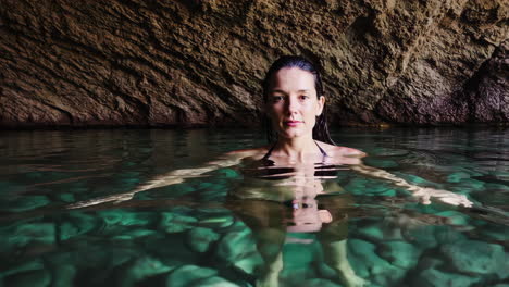 woman swimming in a clear water cave pool