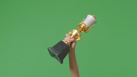 woman holding a champion golden trophy. green screen background