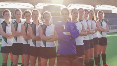 female hockey players standing in a row with arms crossed