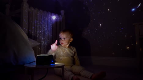 child gazing at star and galaxy projection in bedroom