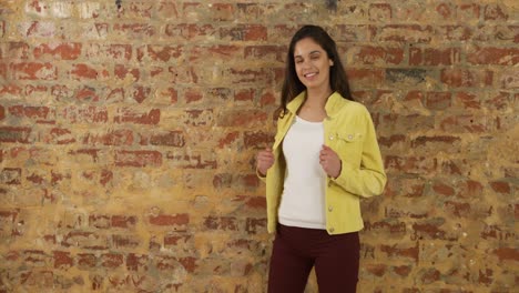 mujer caucásica mostrando su atuendo en una pared de ladrillo