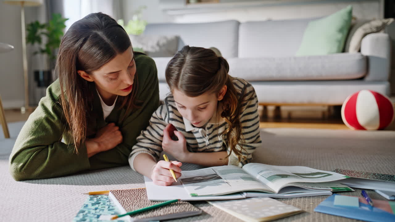Madre e hija despreocupadas estudiando en casa, hojeando libro de texto juntas, primer plano