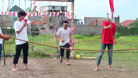young indonesian men celebrate independence day with joyful acrobatics and flag waving, showcasing their festive spirit and energy