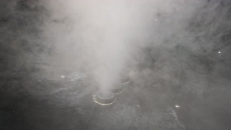 smoke bellows from smoke stacks agains dark background