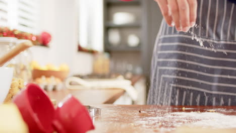 Hombre-Birracial-Con-Sombrero-De-Navidad,-Haciendo-Galletas-De-Navidad-En-La-Cocina-De-Casa,-Cámara-Lenta