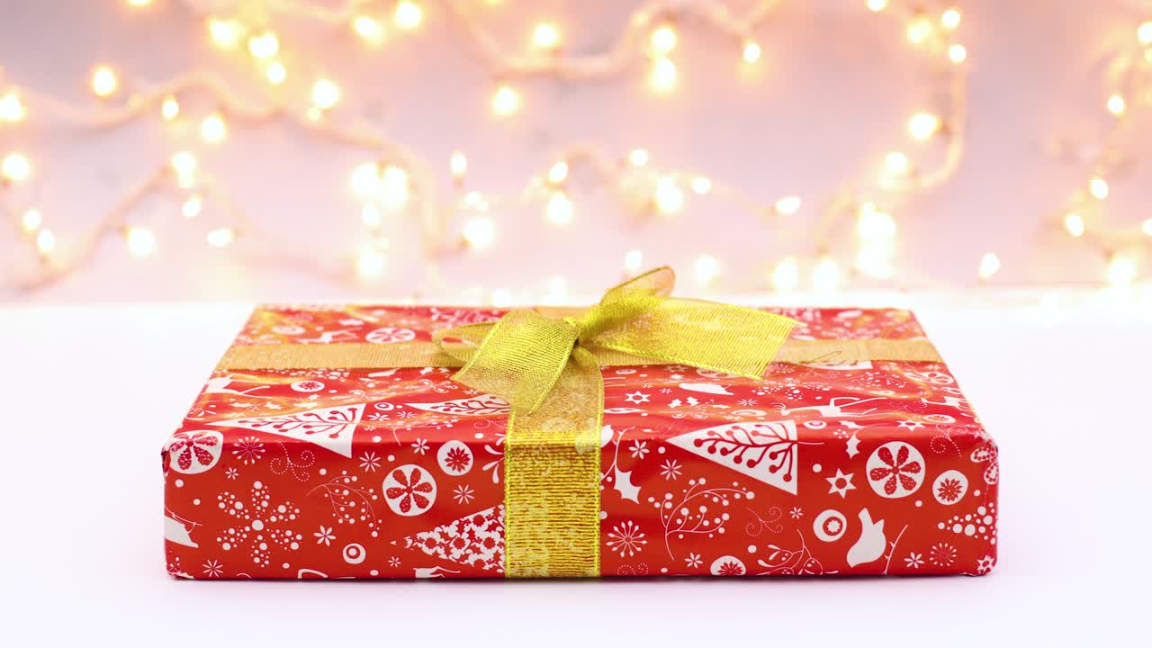금 리본으로 크리스마스 선물이 나타납니다. 스 모션