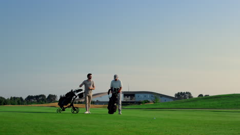 Golfers-discuss-course-game-competition-outside.-Two-men-choose-putters-on-field