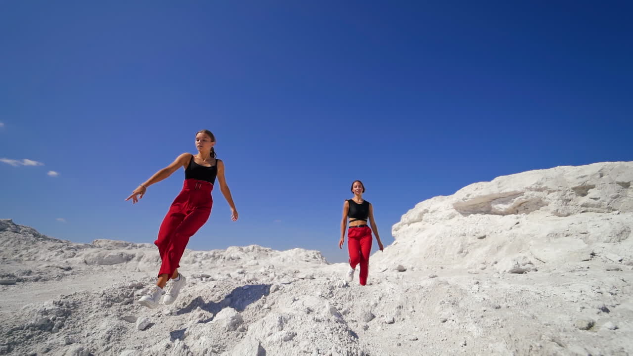 Two Women Dancing in a White Landscape