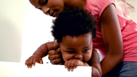 madre sosteniendo a su bebé en su cuna