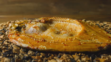 dressed ide fish lies on pile of decayed wooden chips macro