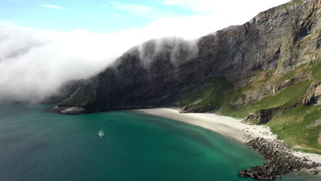 imágenes aéreas de un barco en aguas cristalinas en la isla de vaeroy, islas lofoten en noruega