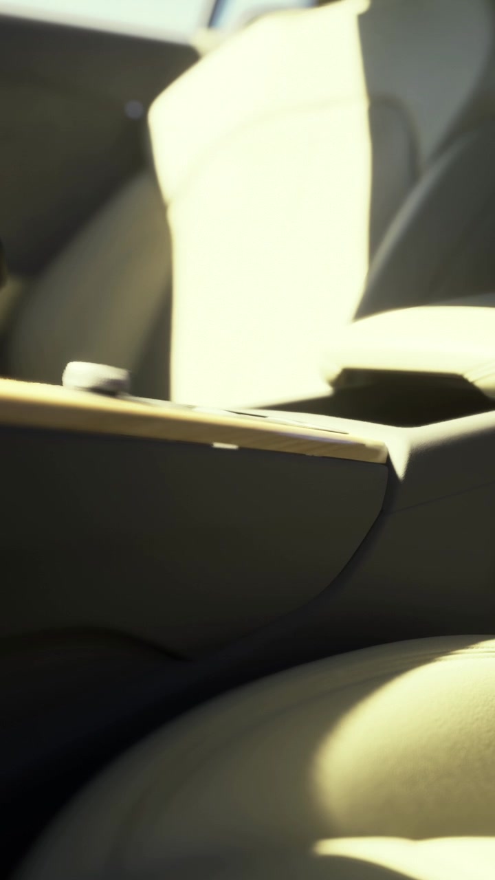 Interni dell'auto che mostrano il bracciolo e la console in piena luce solare di giorno