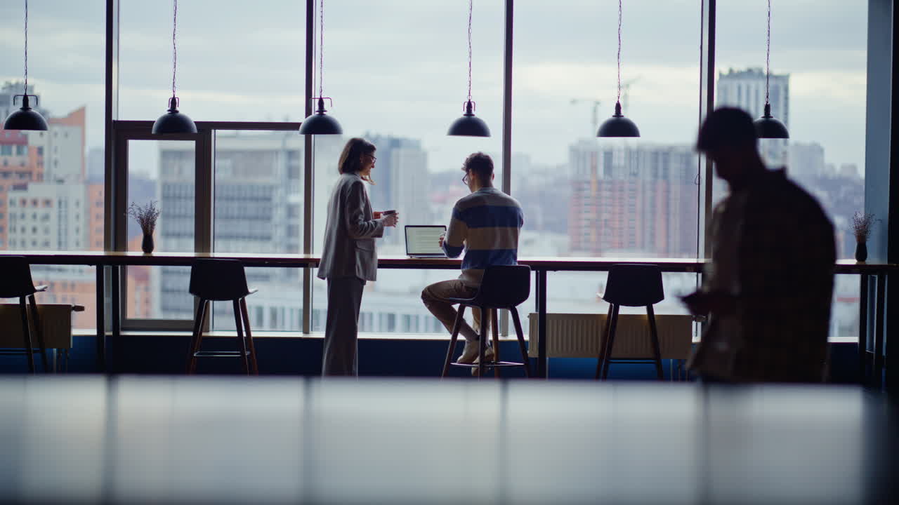 Woman bringing tea colleague panoramic windows coworking space. People talking