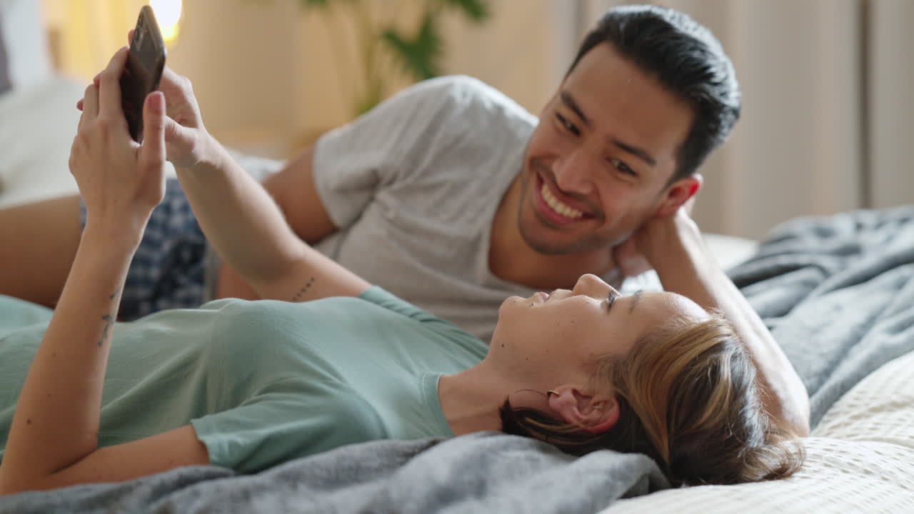 사랑, 전화 및 커플은 침대에서 휴식을 취하고 이야기합니다.