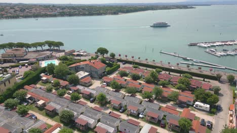 fotografía aérea de una aldea de campamento de mariposas en la orilla del lago en la ciudad de peschiera, lago de garda, italia