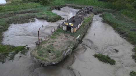 Aerial-View-of-Abandoned-Ship-Covered-With-Grass