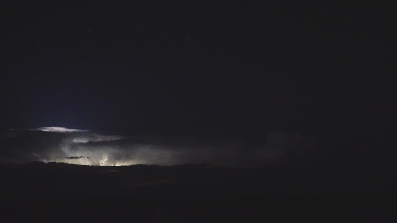 Distant Lightning Storm Flickers And Flashes In The Dark Night Sky
