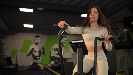 woman working out on a stationary bike in the gym