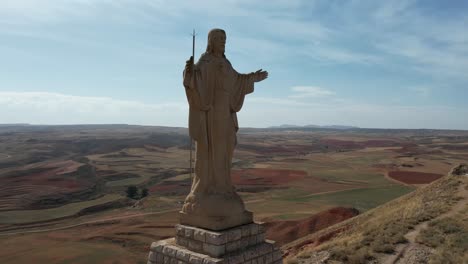 round drone flight around a huge jesus christ statue in spain, in an atumn afternoon