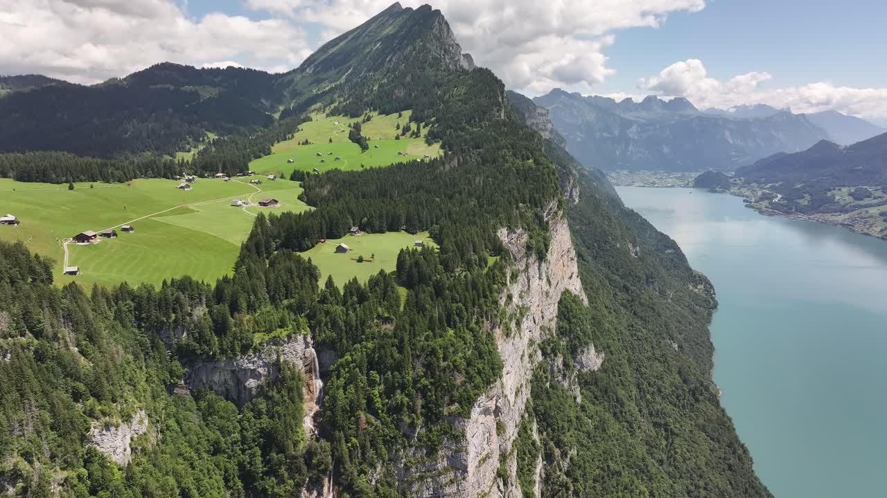 Aerial view captures the turquoise waters of Walensee in Switzerland, revealing the scenic stretch between Weesen and Betlis. The lake is flanked by steep, lush green mountains