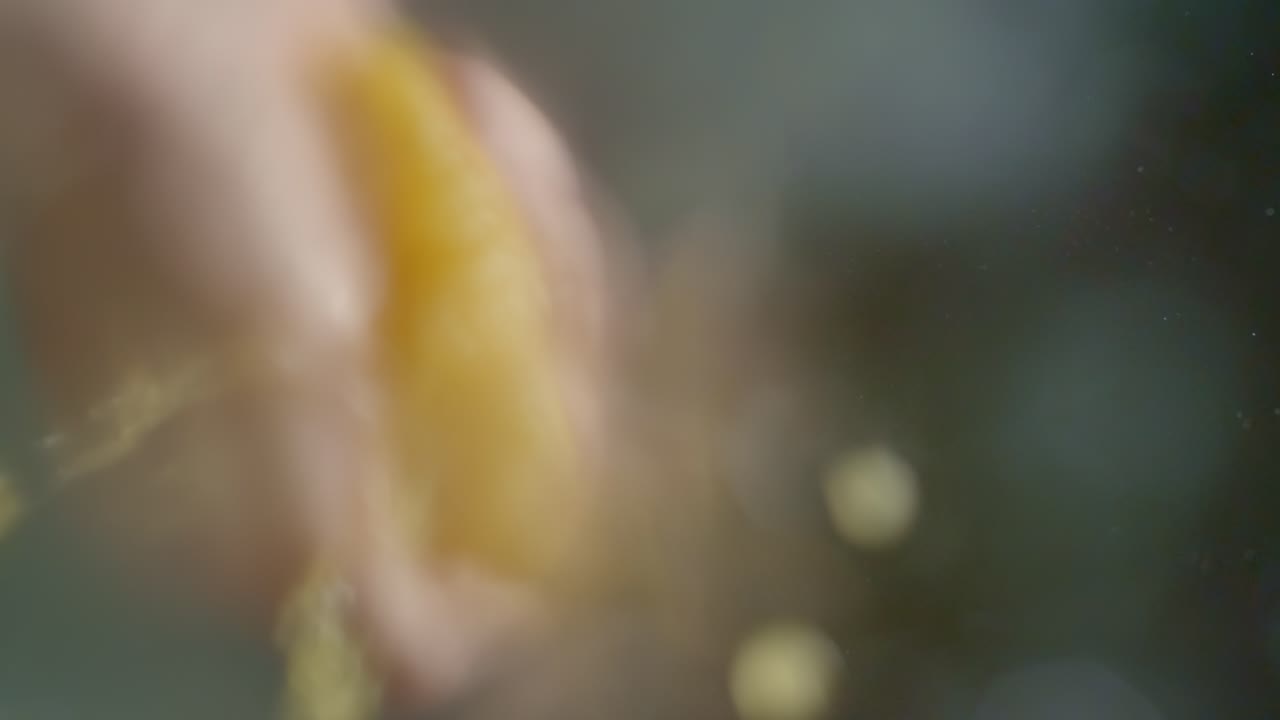 una persona exprime una mitad de naranja