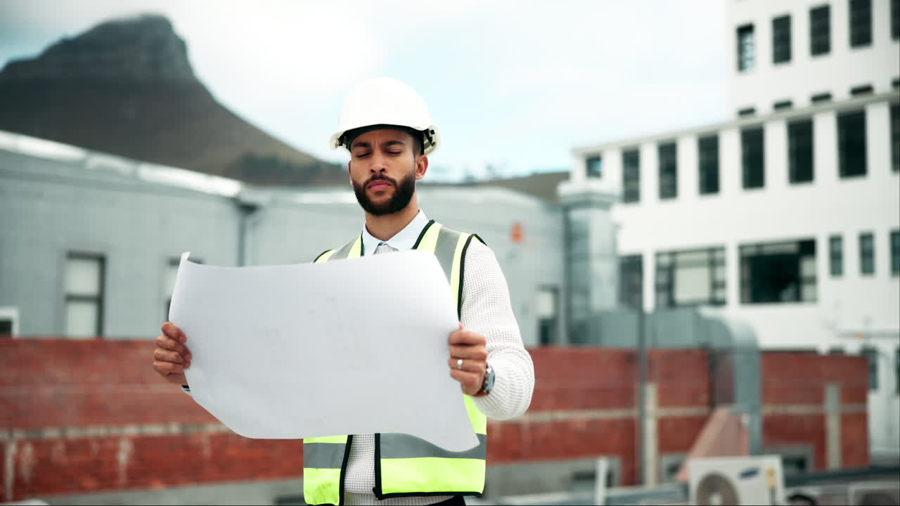 Construction worker with blueprint on site