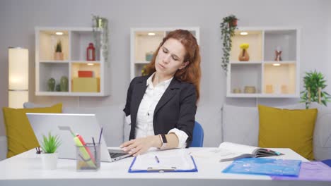 una mujer que trabaja en la oficina tiene dolor de espalda.