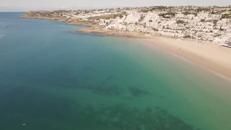 escena tranquila, océano esmeralda en calma y casas adosadas blancas de praia da luz