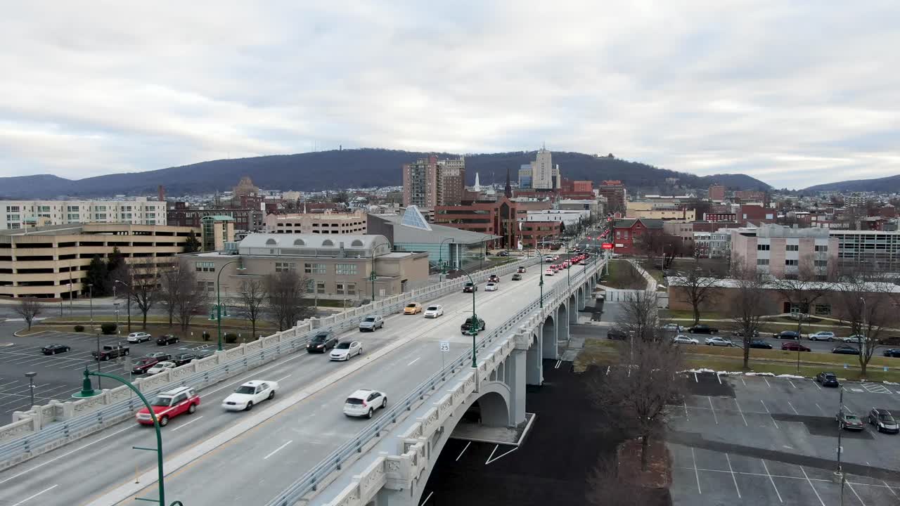 Morning commute into Reading City, PA, school bus, cars travel to jobs in downtown urban setting, aerial drone view during winter, bare trees, no leaves