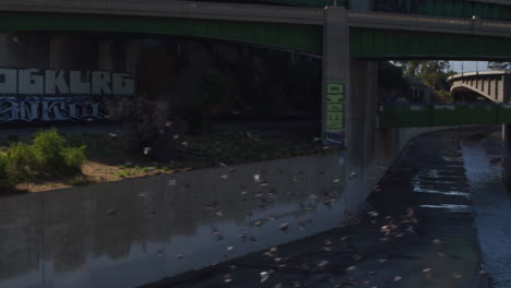 drone shot of los angeles traffic going on a bridge above the iconic la river