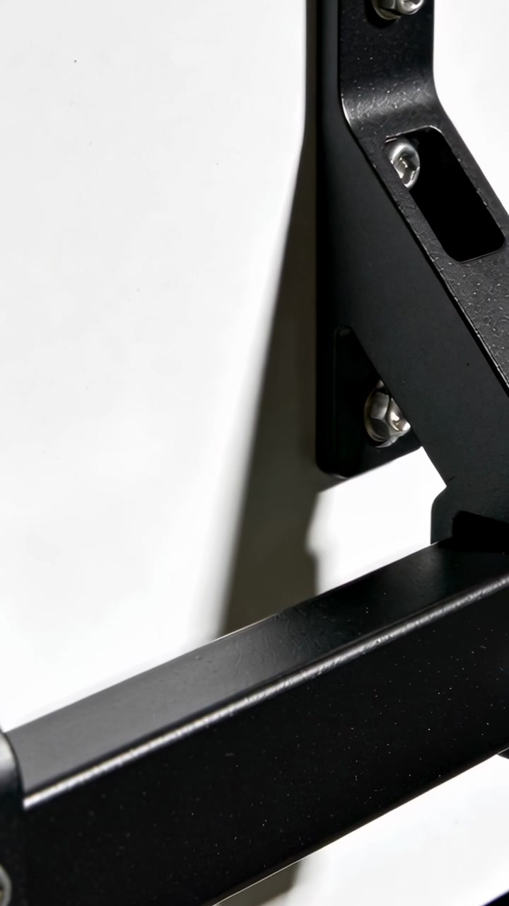Vertical video: Panning camera to reveal bracket bar on white wall, showing bolts, slot, copy space