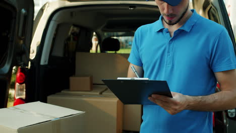 delivery person checking packages in van