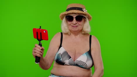 anciana pensionista mujer turista tomando una foto de retrato selfie, haciendo una llamada de video en teléfono móvil