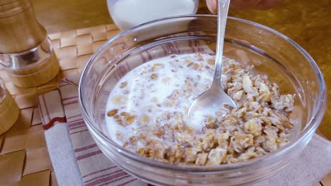 whole grain cereal muesli in a bowl for a morning delicious breakfast with milk. slow motion with rotation tracking shot.