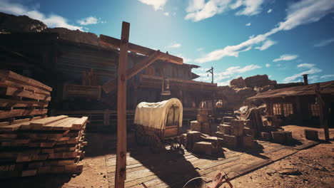 a rustic western town with wooden structures and wagons in bright sunlight