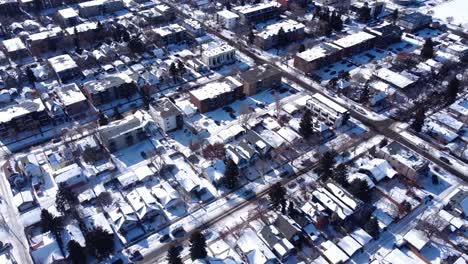 Entdecken-Sie-Den-Kontrast-Von-Strahlendem-Sonnenschein-Und-Verschneiten-Landschaften-Mit-Diesen-Atemberaubenden-Drohnenaufnahmen-Einer-Winterlichen-Innenstadt,-Die-In-Sonnenlicht-Getaucht-Ist