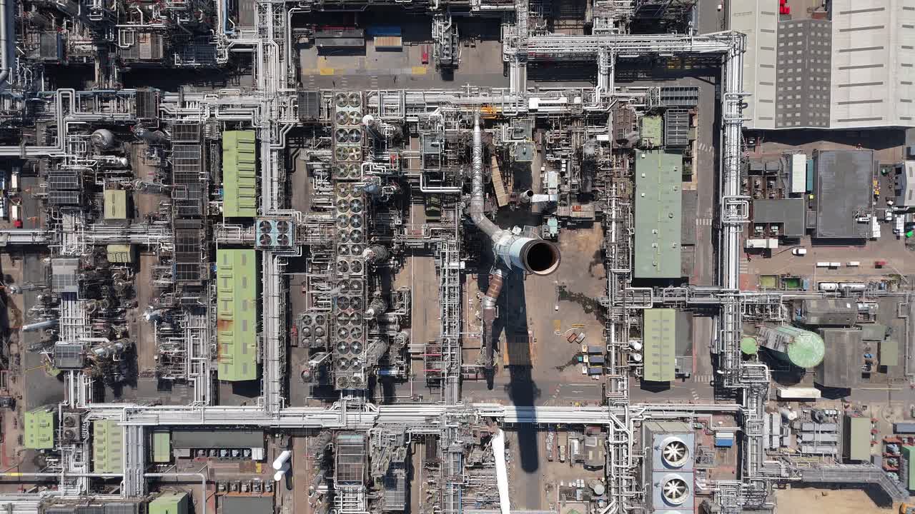 Rekaman drone udara sinematik pabrik kimia dengan asap industri, suar, dan silo penyimpanan bahan bakar besar dekat Immingham, Inggris, Britania Raya.
