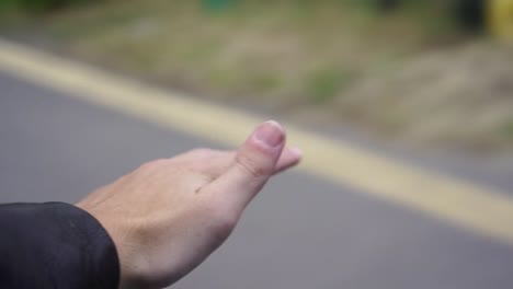 mão para fora da janela do carro sentindo a brisa