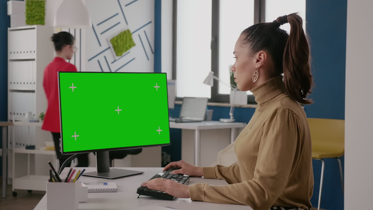 Business woman looking at display with green screen