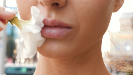 mujer oliendo una flor