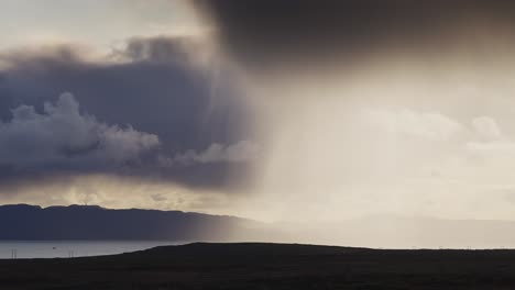 la lluvia cae de las oscuras nubes tormentosas iluminadas por el sol
