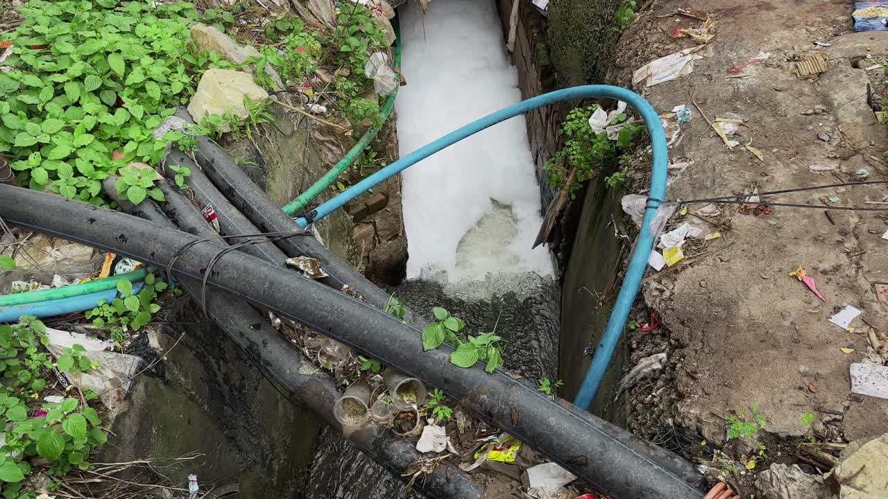 wide angle shot of a scene of environmental pollution and potential health hazards, an urban or semi-urban area where Exposed Pipelines is a Contamination Risk for fresh water