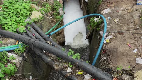 wide angle shot of a scene of environmental pollution and potential health hazards, an urban or semi-urban area where exposed pipelines is a contamination risk for fresh water
