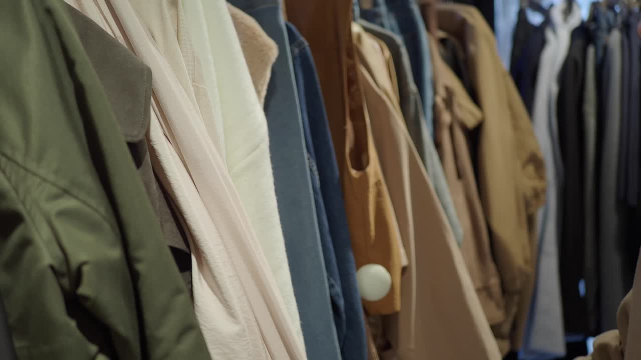 ラックにかかった服を閲覧する女性
