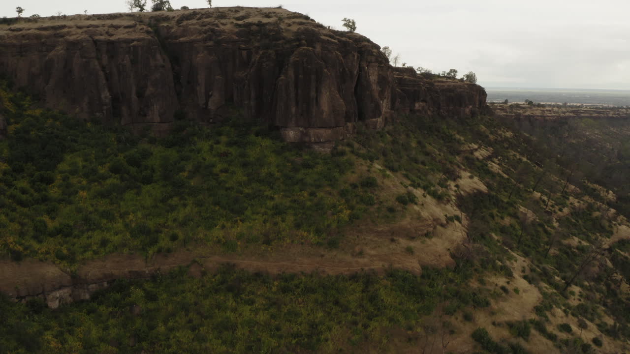 Aerial: California butte peak overlooking canyon mountain plateau, cloudy day