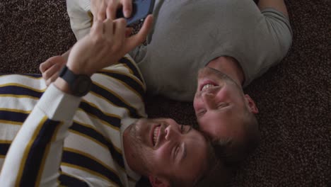 pareja de hombres caucásicos en distanciamiento social en su sofá en casa