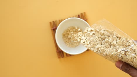 pouring oatmeal from a bag into a bowl